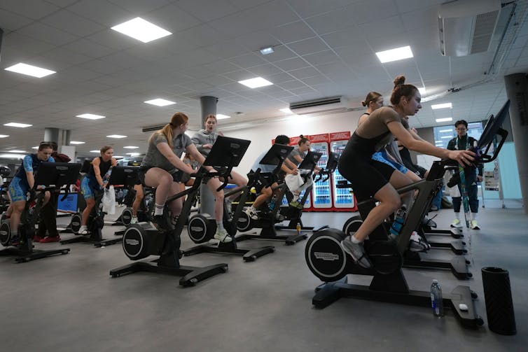 Cuando el norovirus llega a los Juegos Olímpicos: la ciencia detrás de la propagación 2 Personas que utilizan equipos de ejercicio en una habitación grande.