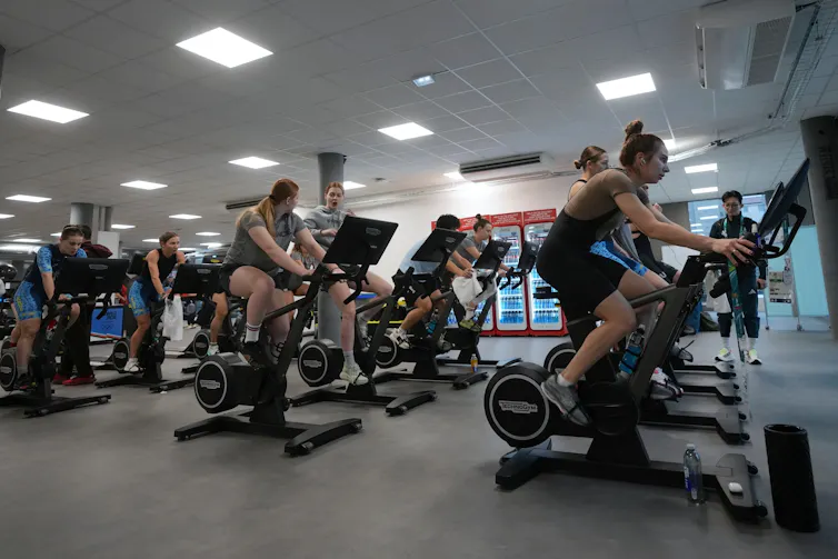 People using exercise equipment in a large room