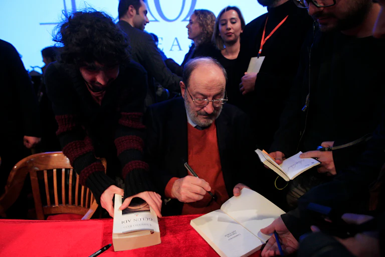 Un hombre firma libros.