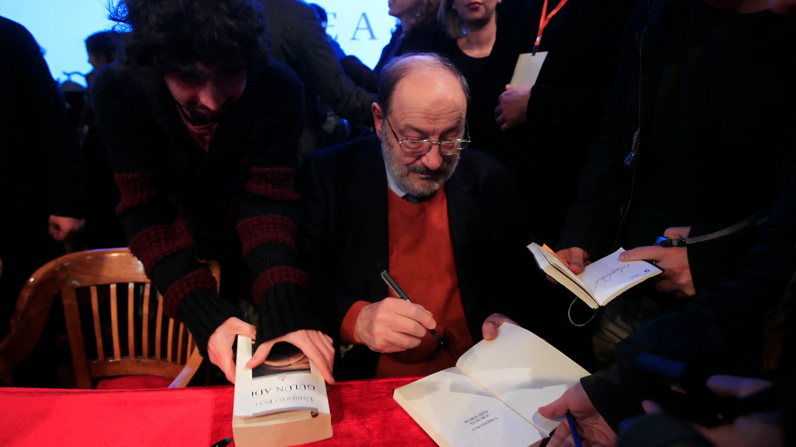 Un hombre firma libros.