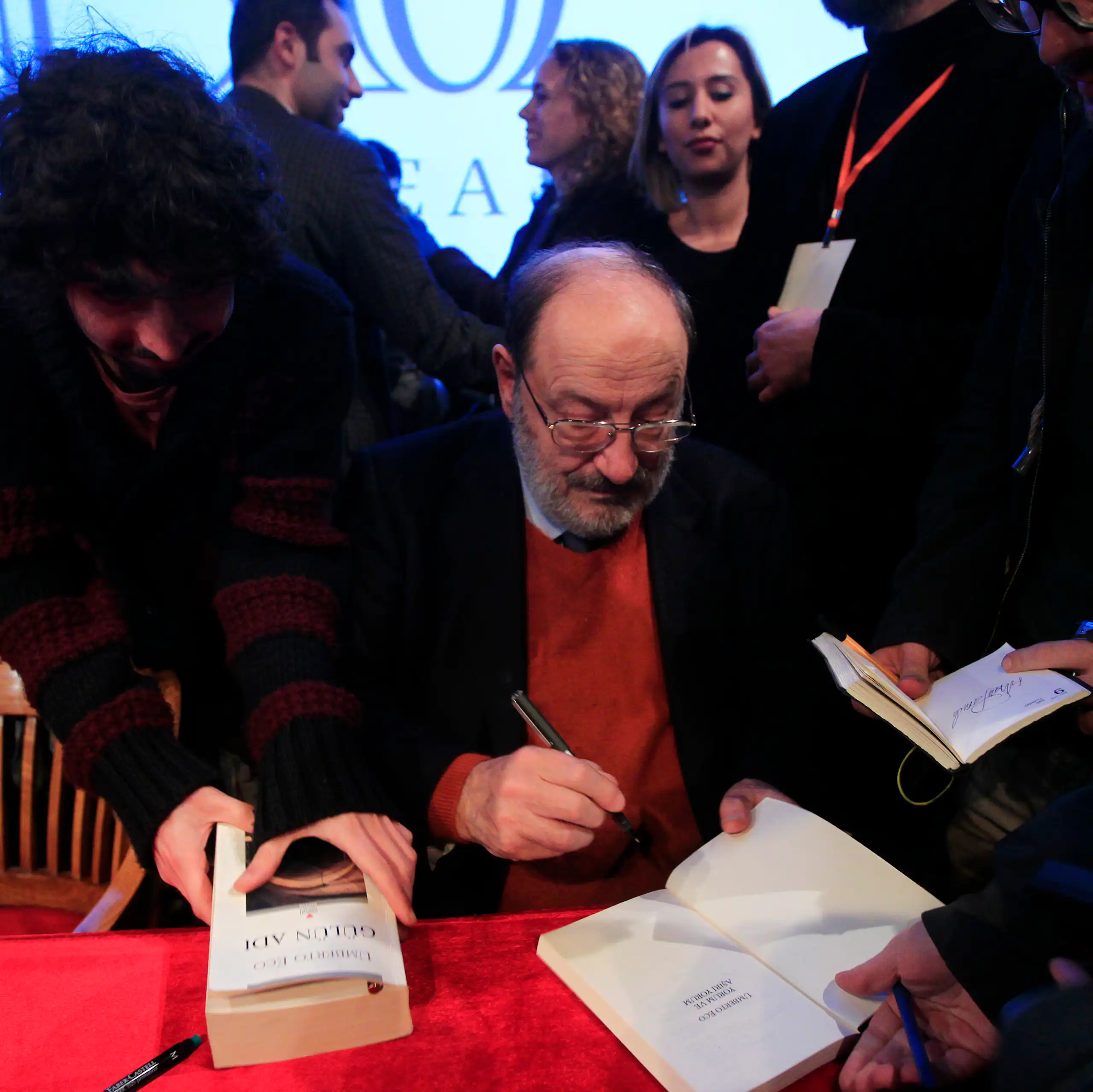 Un hombre firma libros.