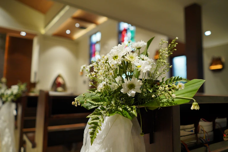 A colourful bunch of flowers in a vase in a church.
