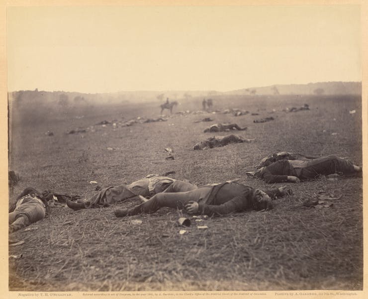 The bodies of dead soldiers strewn across a field.