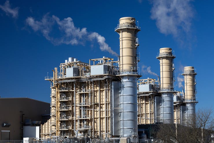 A large building with pipes and exhaust towers.