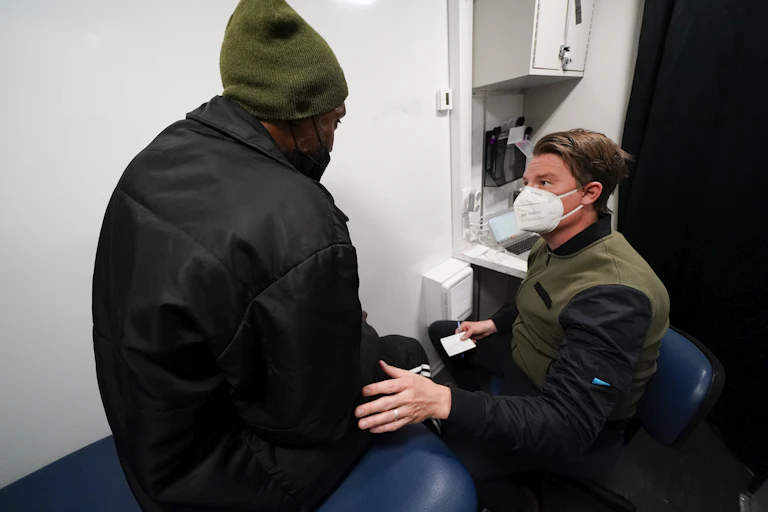 Two men speak in a medical setting