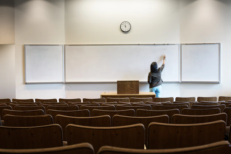 Picture of university teacher in empty classroom.