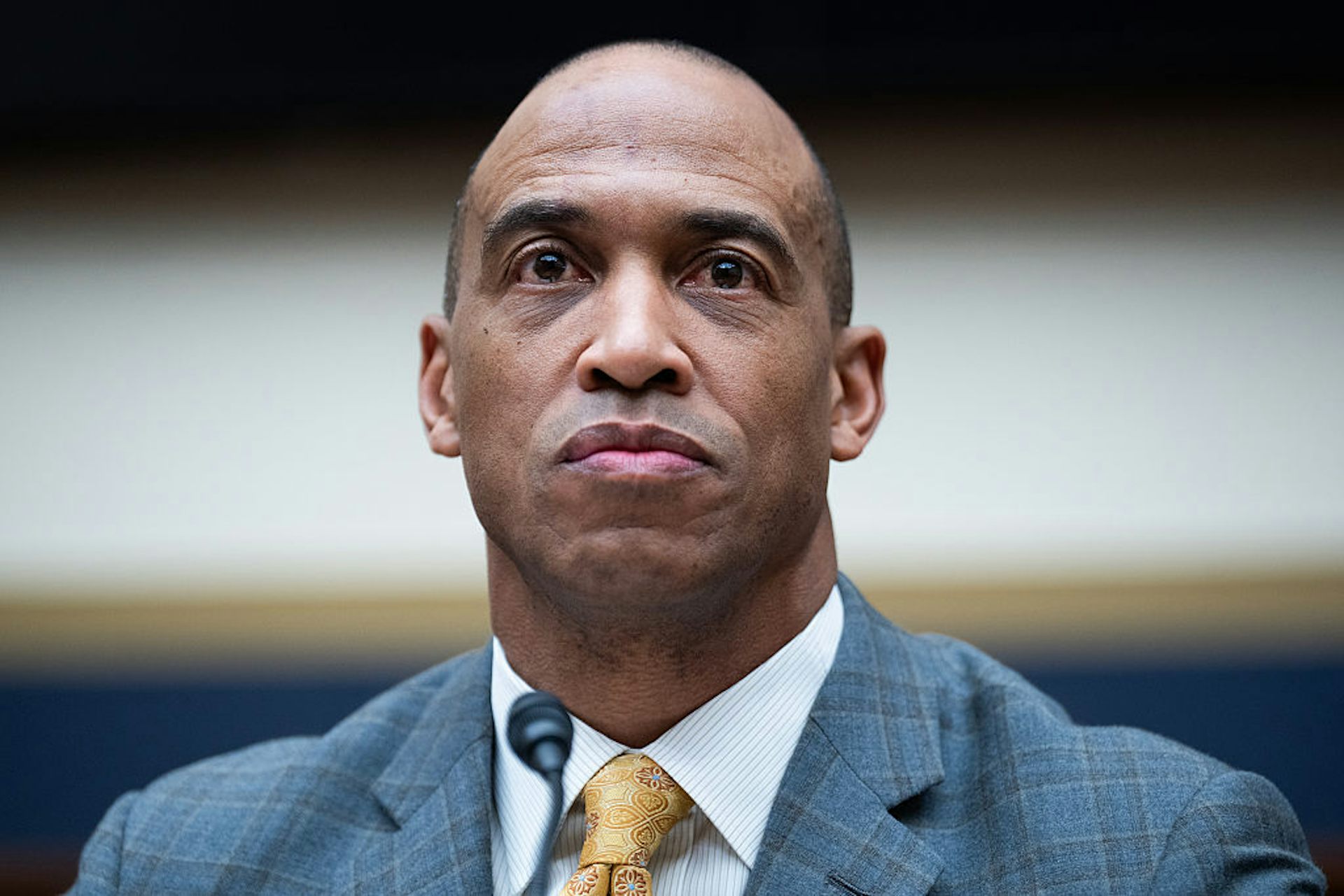 Color portrait of a Black man in a light blue suit and yellow tie