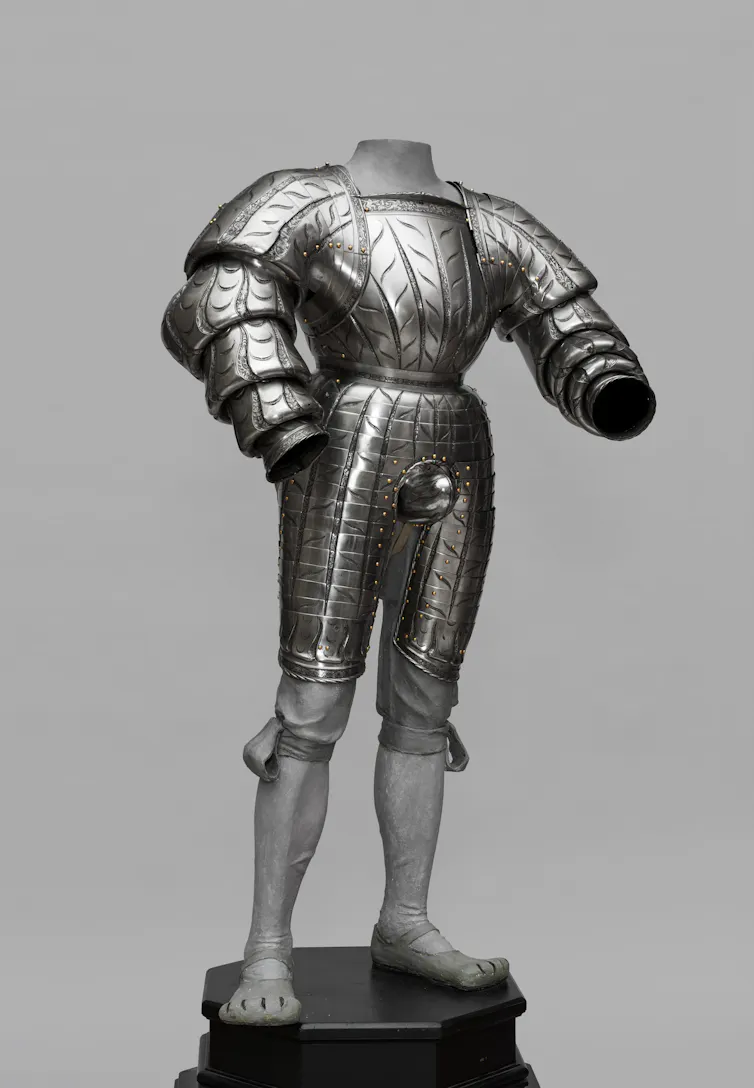 A tall suit of metal armour, modelled to look a garment with puffy sleeves.