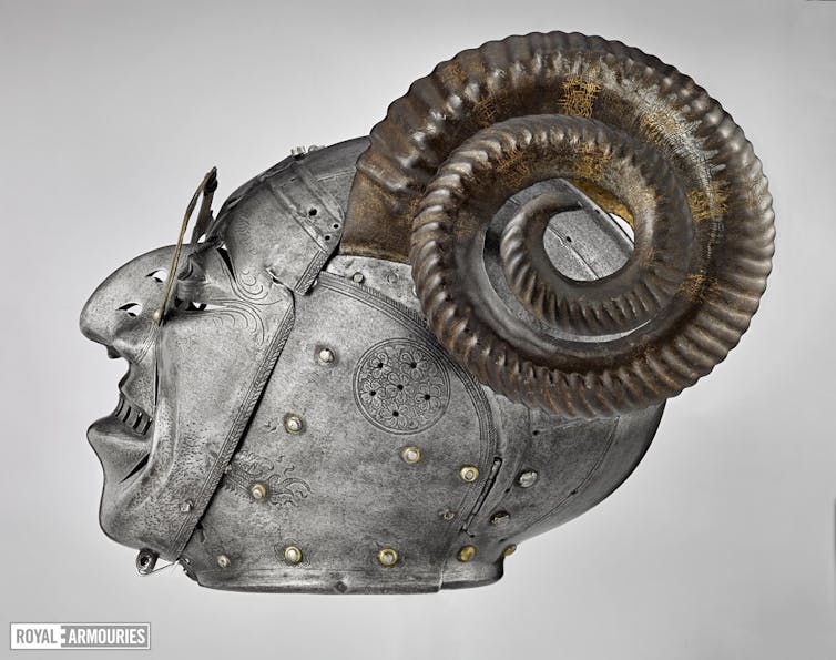 Side view of a steel helmet with golden spectacles and ram horns.