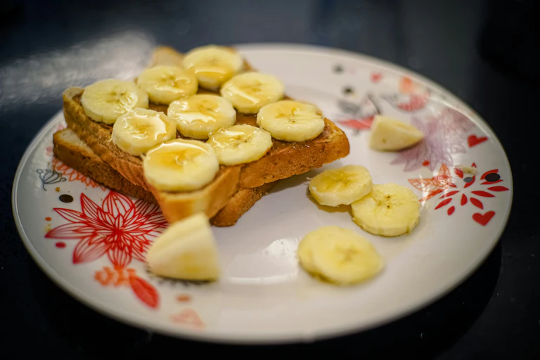 honey used on banana and toast served on a plate