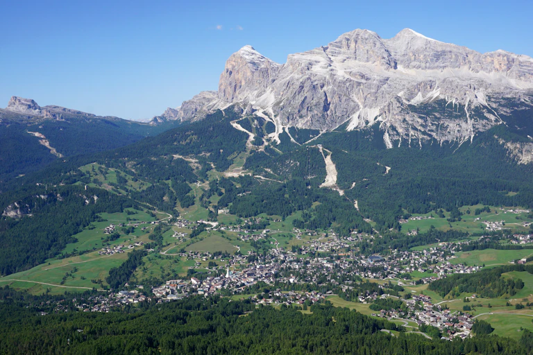 A mountain rises behind a small town in the Italian Alps.