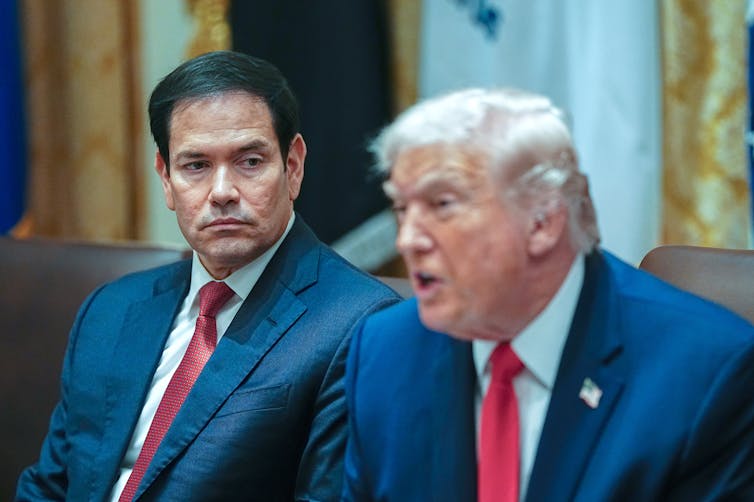 Marco Rubio sits next to Donald Trump during a meeting.