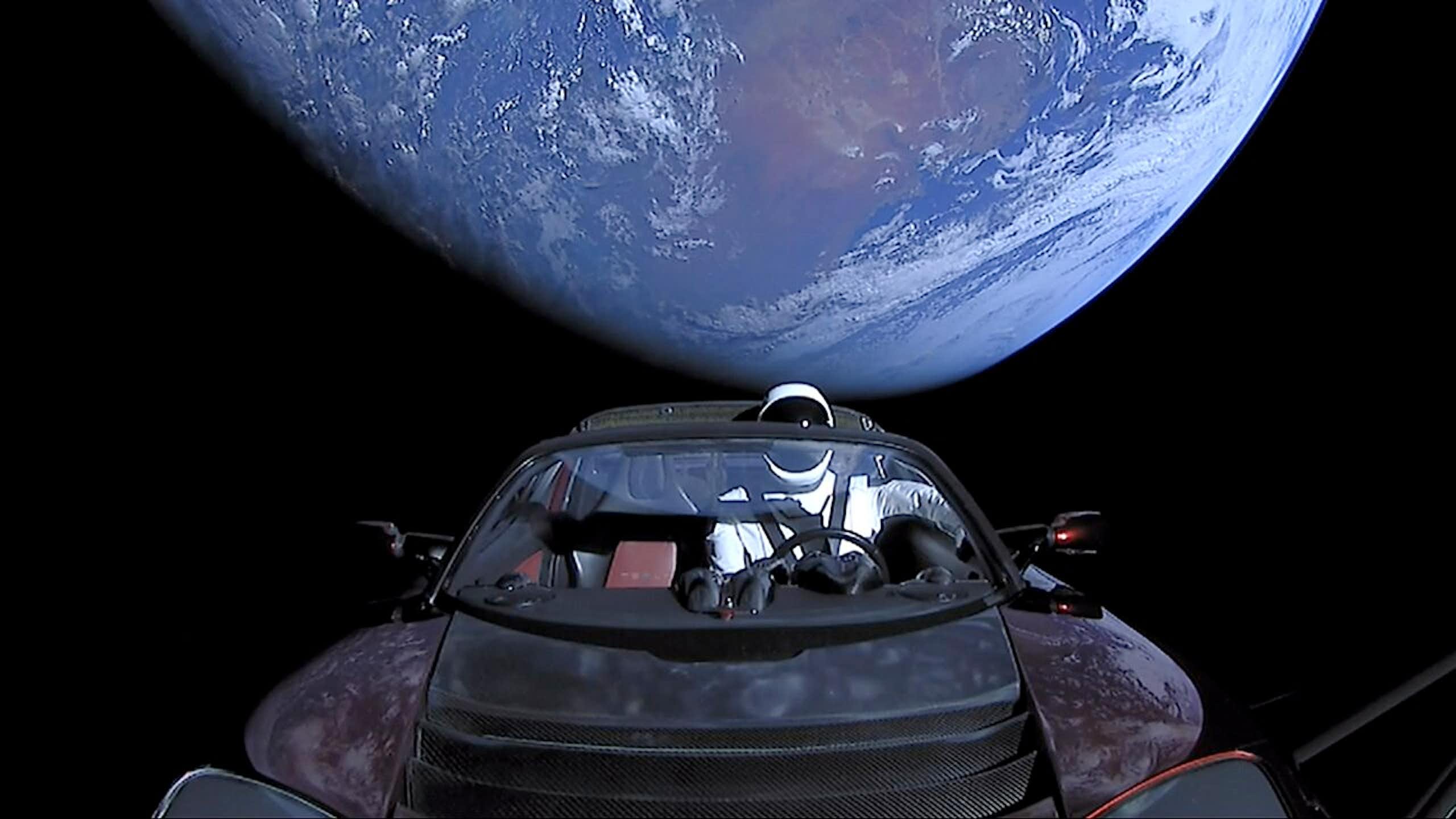 photo de voiture dans l'espace, avec vue sur la Terre
