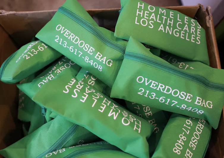 Box filled with green bags labeled Overdose Bag from Homeless Health Care Los Angeles