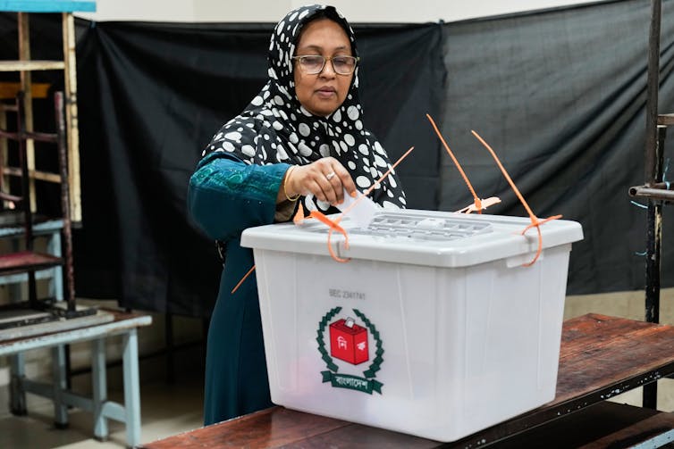 Las elecciones en Bangladesh son la política habitual y algunos esperan un cambio 2 Una mujer que lleva un hiyab deposita su papeleta en una urna en un colegio electoral