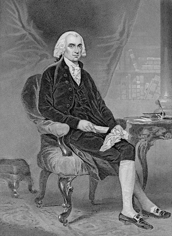 A stately man in a white wig, black waistcoat and knee breeches sits cross-legged beside a wooden side table.