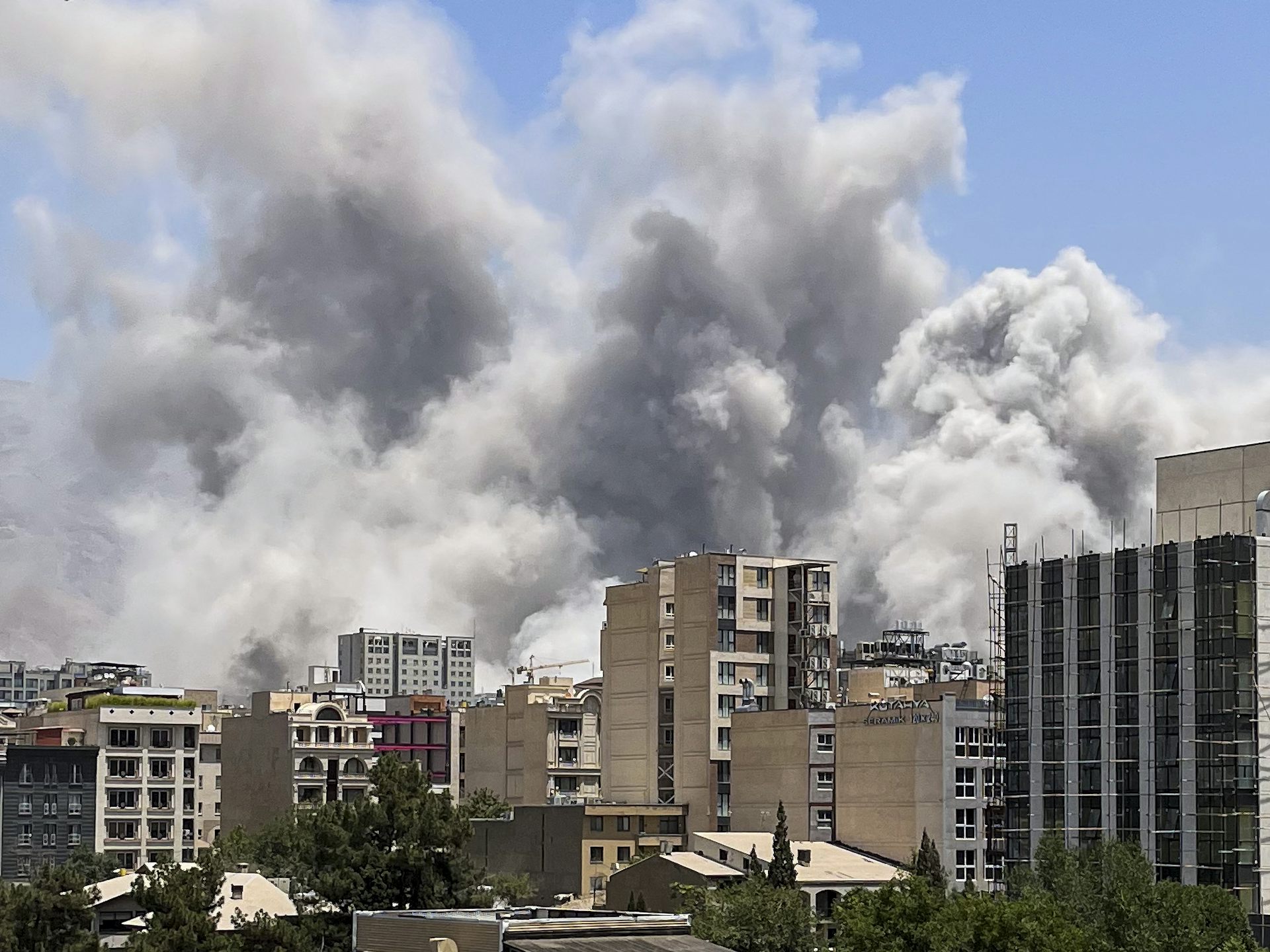Plumes of smoke are seen above buildings