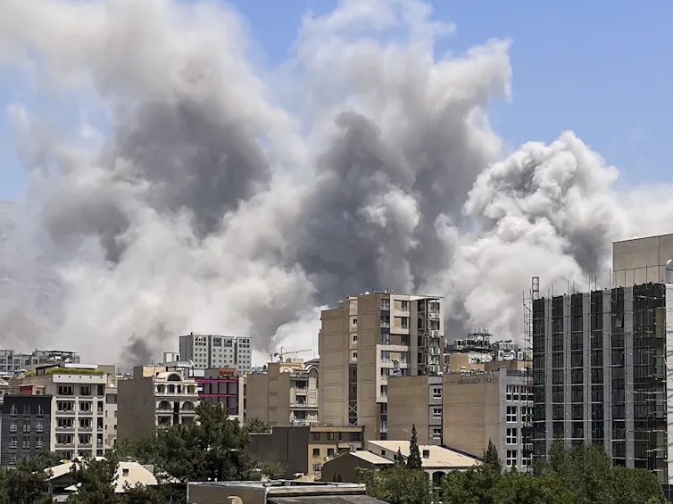 Plumes of smoke are seen above buildings