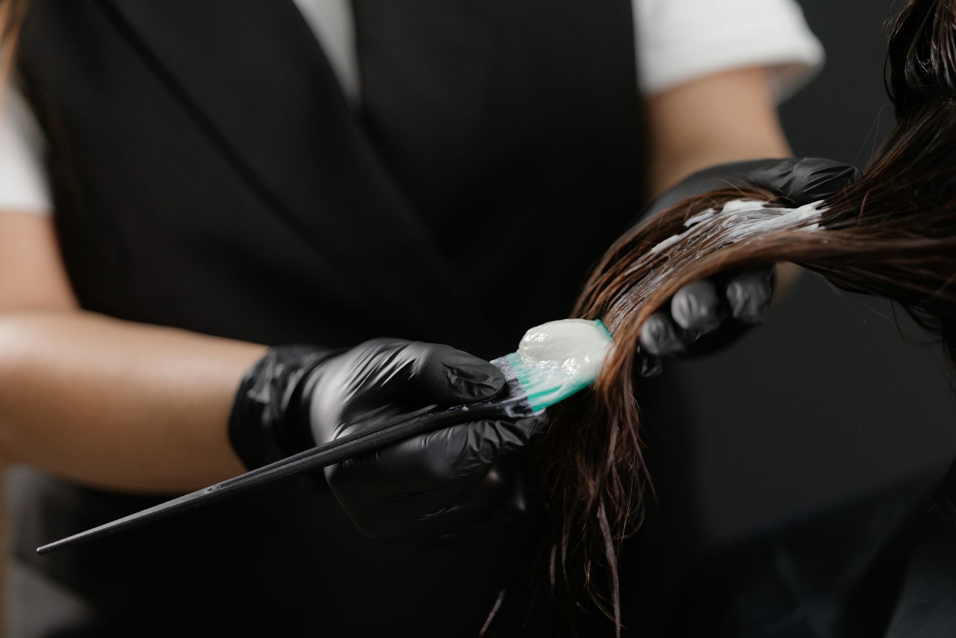 Application d’un produit lissant sur une chevelure dans un salon de coiffure