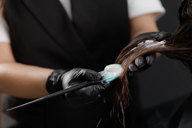 Application d’un produit lissant sur une chevelure dans un salon de coiffure