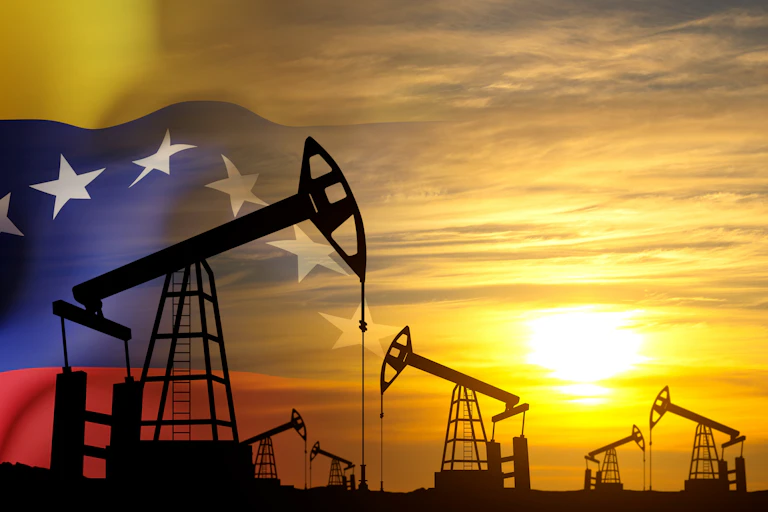 Oil pimps in silhouette against sunset merged with Venezuelan flag.