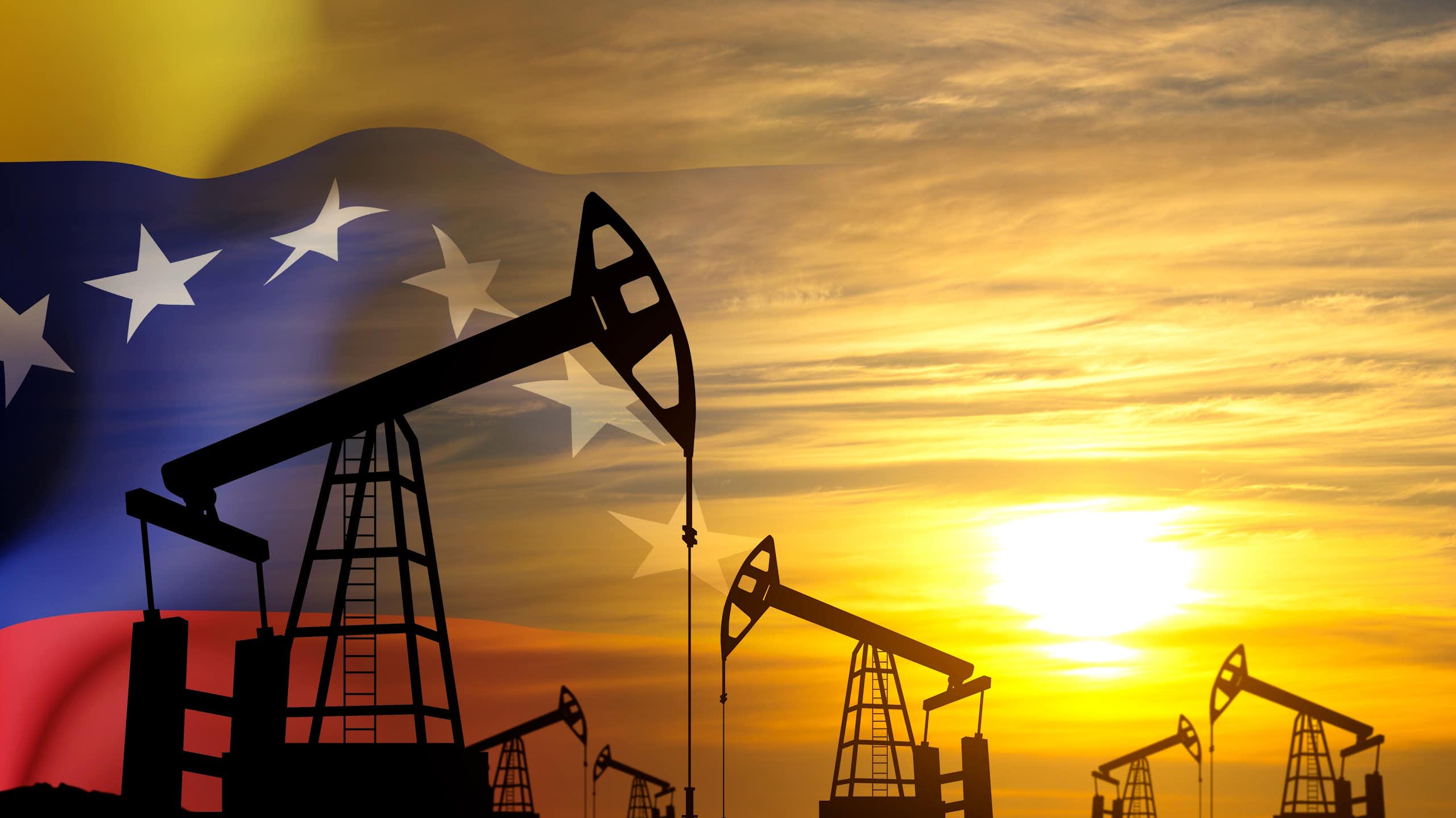 Oil pimps in silhouette against sunset merged with Venezuelan flag.