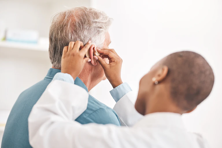 Doctor helping and man with hearing aid