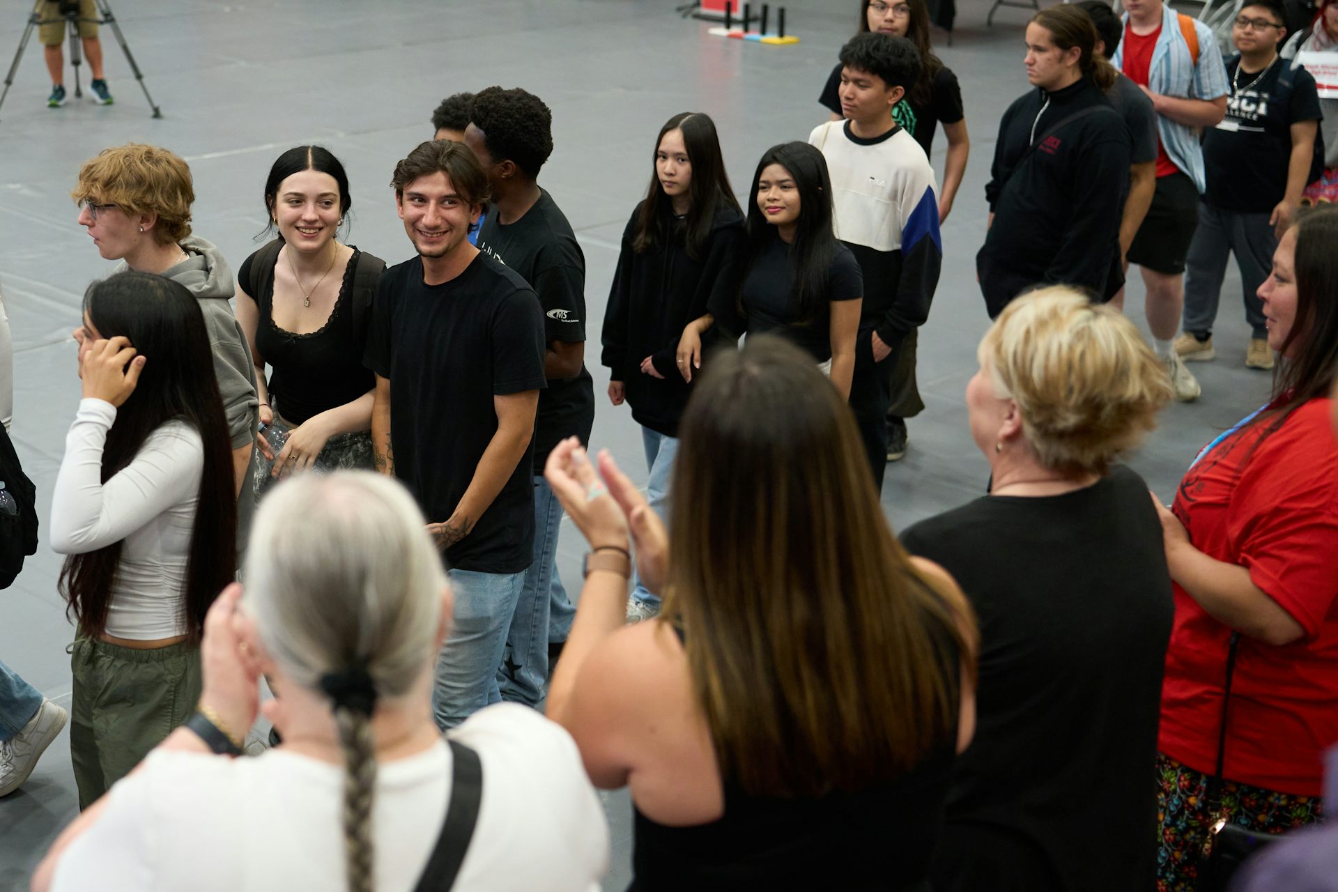 la gente forma una fila mientras otros aplauden desde el costado