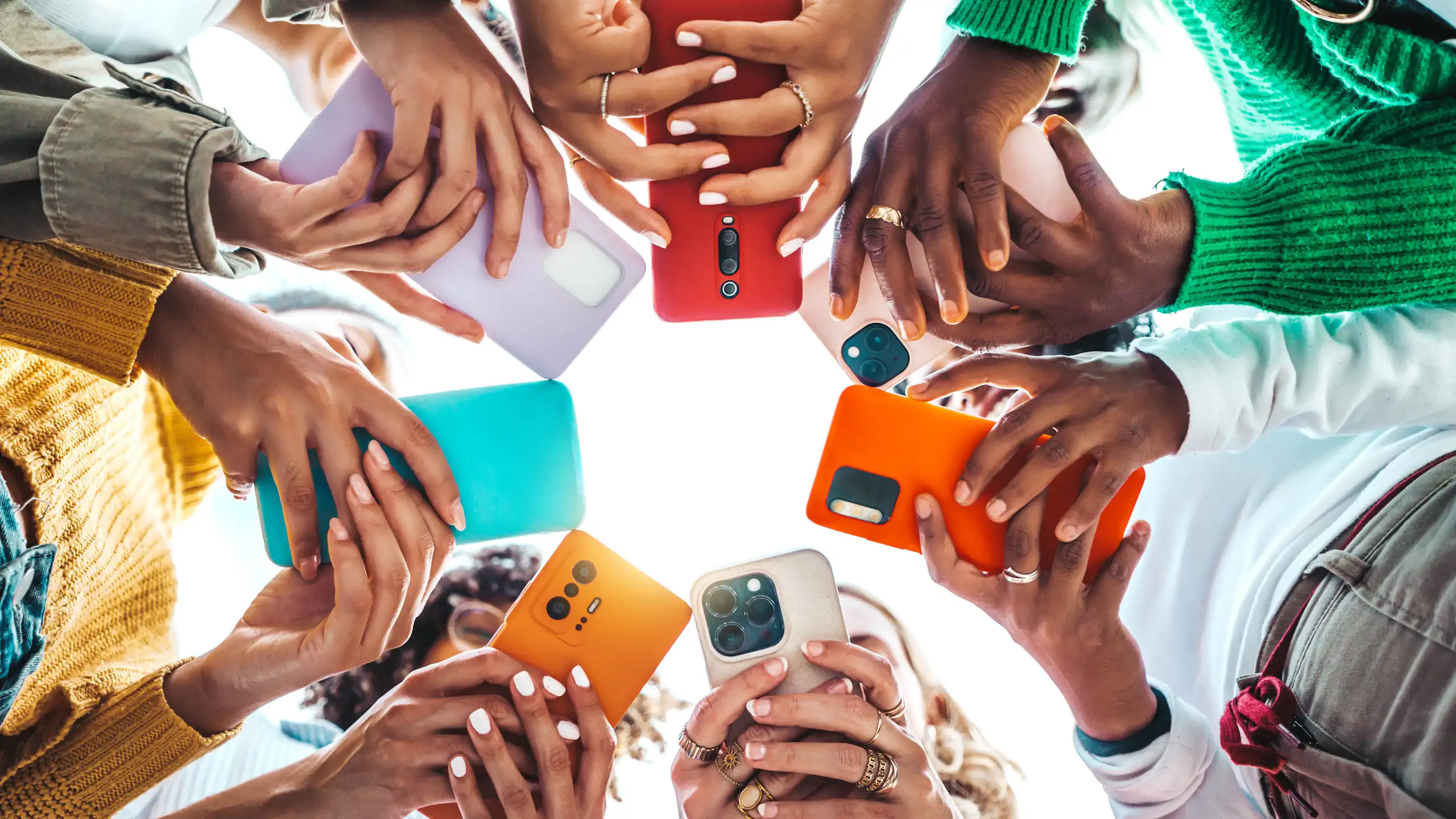 Hands holding smartphones shot from below