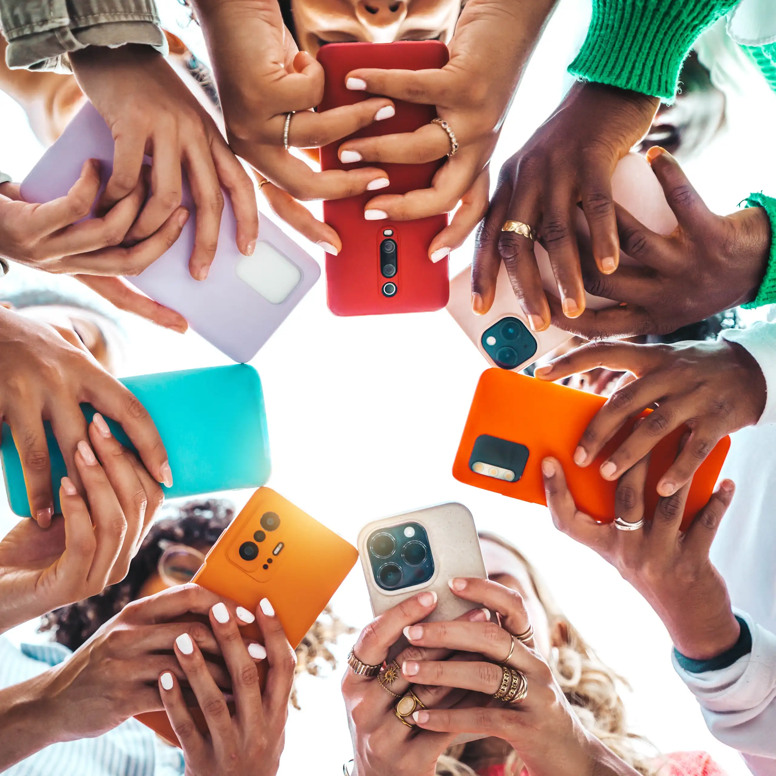 Hands holding smartphones shot from below