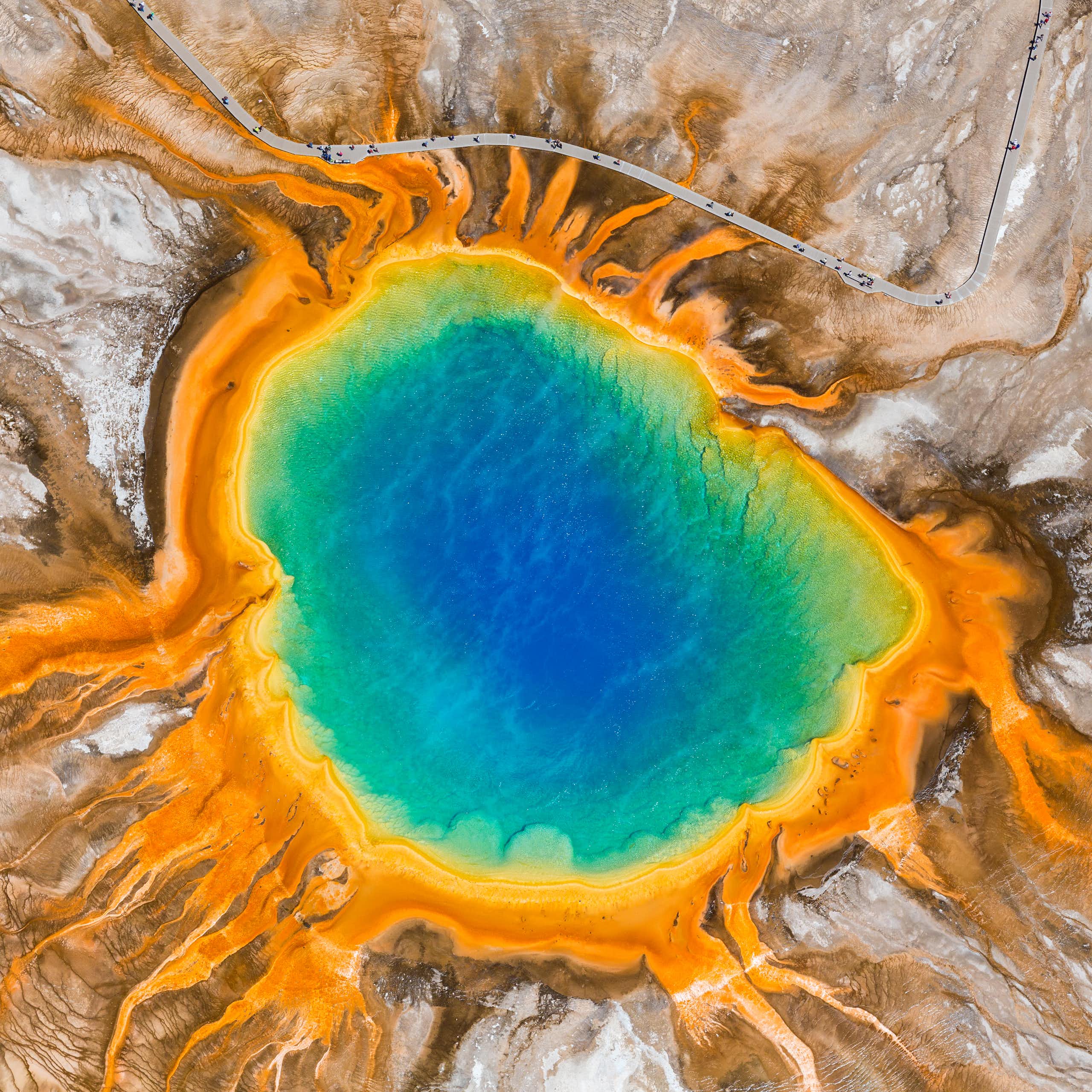 Vista aèria d'un llac amb colors blau, verd, groc i taronja, de dins cap a fora.