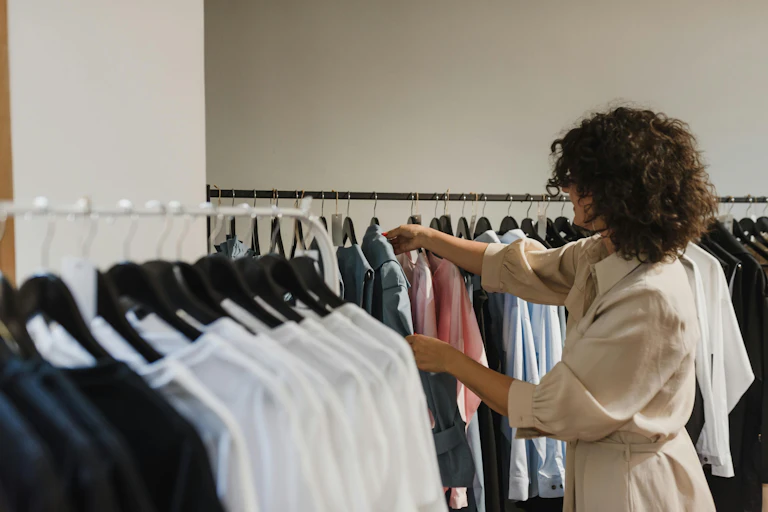 A woman browses a clothes rack in a store