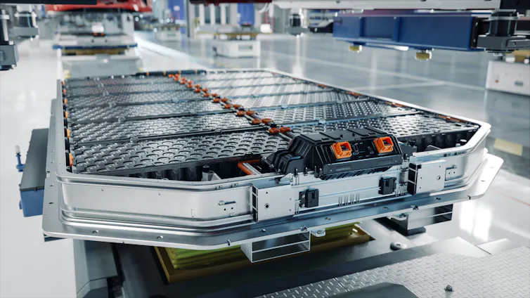 an electric vehicle battery pack being built, flat packs of batteries grouped together.