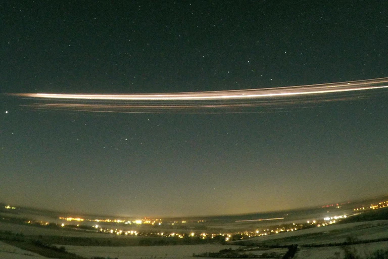 A streak of bright light against a night sky.