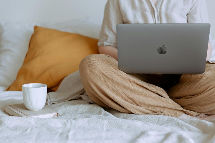 Woman using laptop in bedroom.