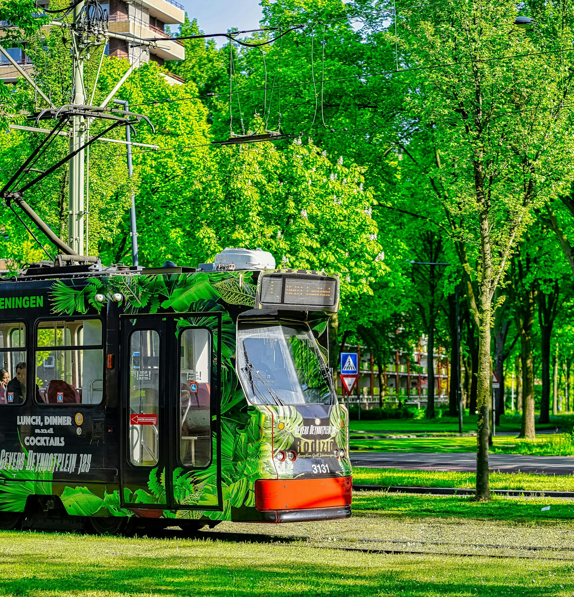 a tram running along green tram tracks