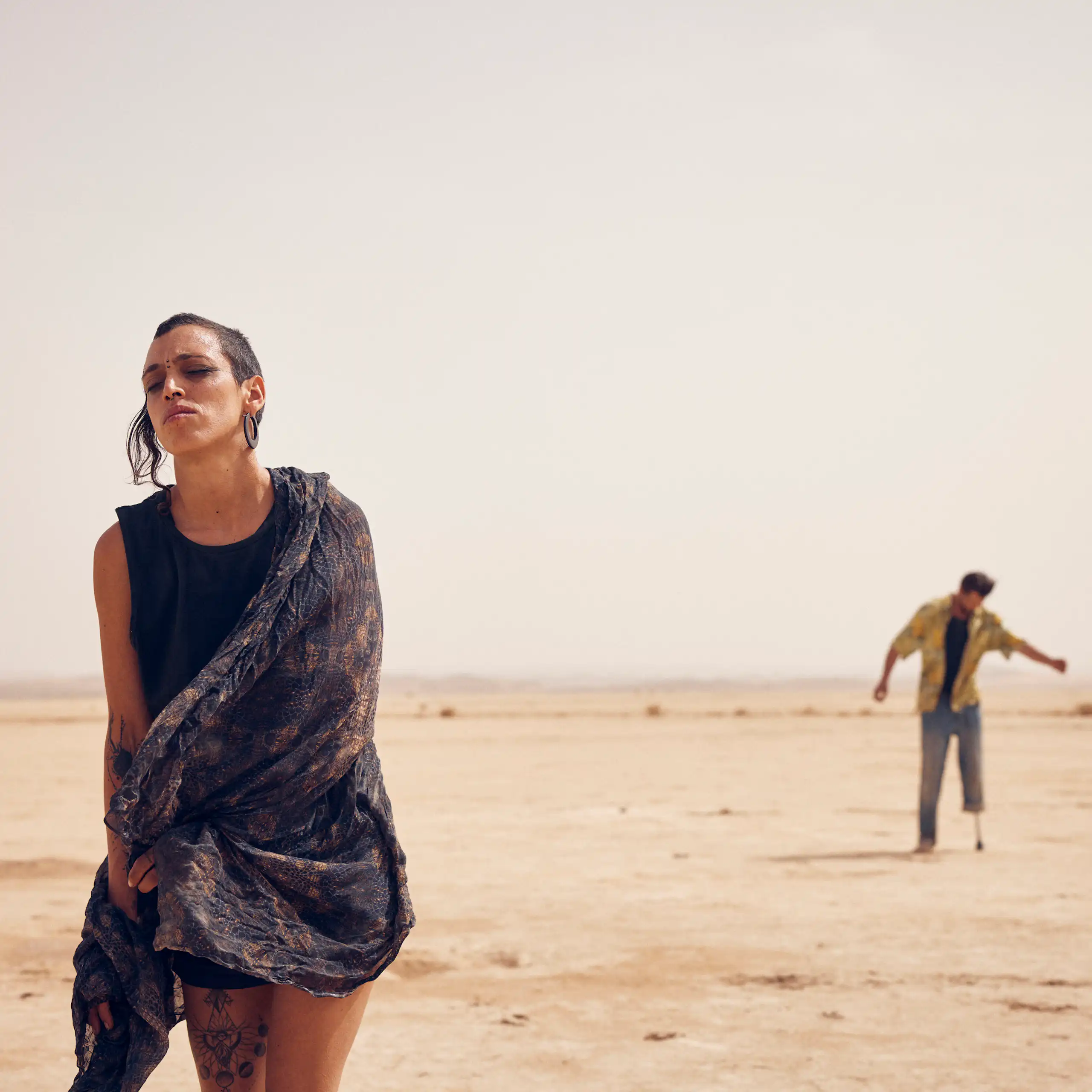 Dos personas bailan en el desierto.