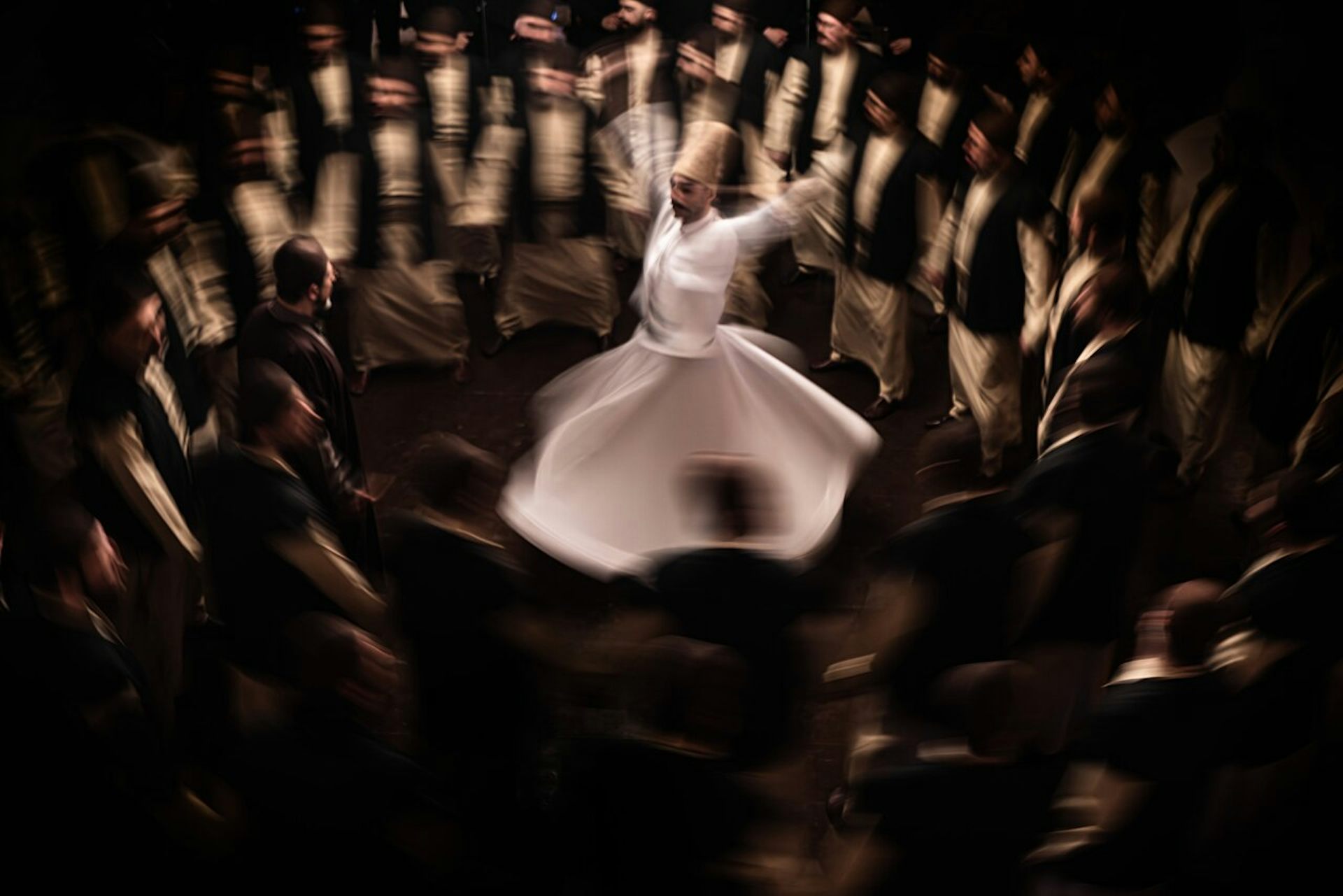 Una imagen de un hombre bailando mientras gira rodeado de otros hombres.