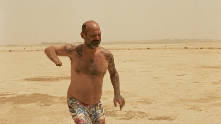 ¿Y si dejáramos todo y nos fuéramos al desierto? 'Sirat' y la tentación de desaparecer de uno mismo 1 Un hombre con un brazo amputado baila en el desierto.