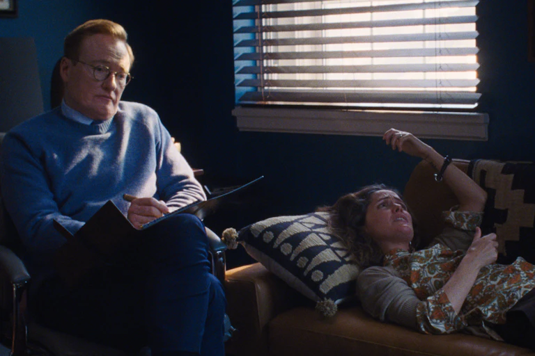 Rose Byrne lies on a couch while her therapist, Conan O'Brien sits in a chair next to her