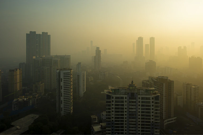The built-up Indian city of Mumbai at sunrise, shrouded in thick smog.