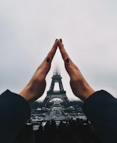 A picture of two hands framing the Eiffel tower