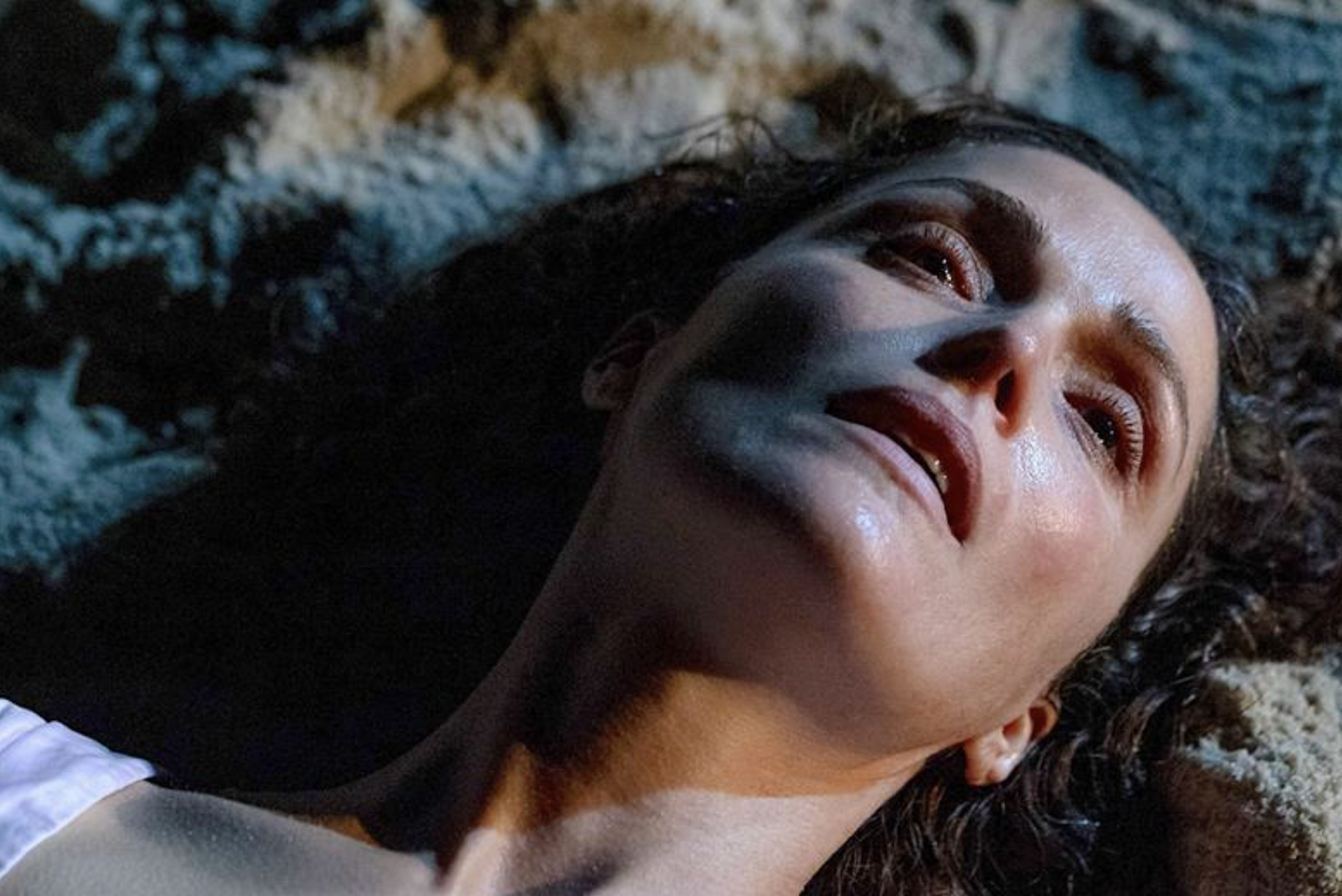 A woman lying on the floor looking defeated.