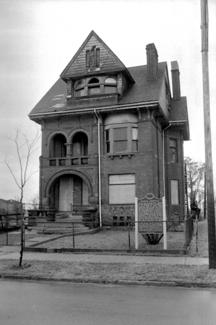 Detroit alguna vez fue el hogar de 18 hospitales administrados por negros: aquí le mostramos cómo comprender su ascenso y caída 2 En la fotografía en blanco y negro, un magnífico edificio de ladrillo de tres pisos se encuentra en un patio con césped.