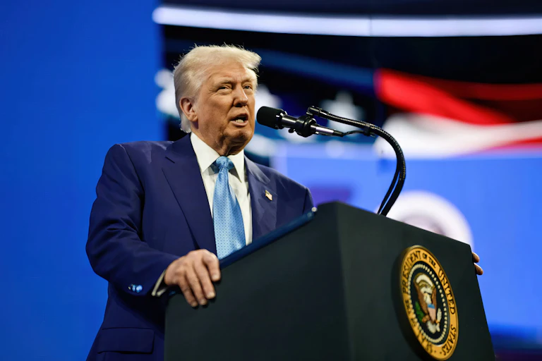 Donald Trump hablando frente a un micrófono en un atril