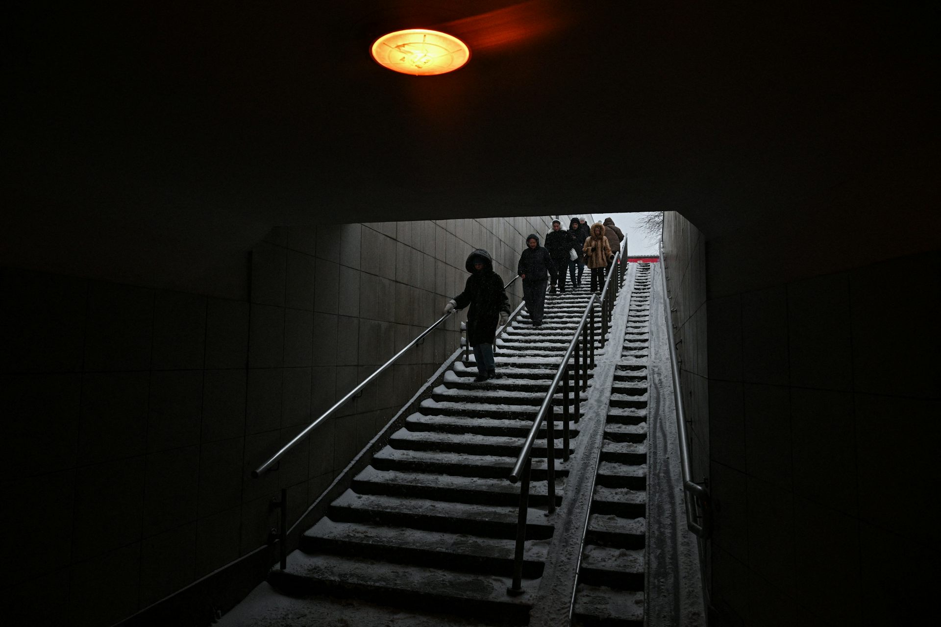 A group of people walk down some steps