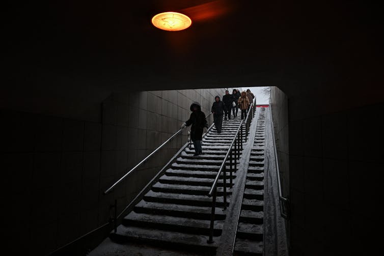 A group of people walk down some steps