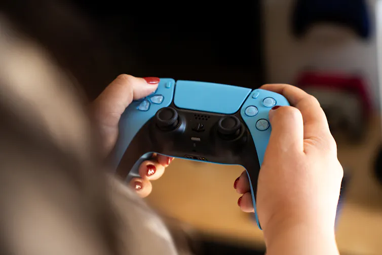 a pair of hands hold a game controller