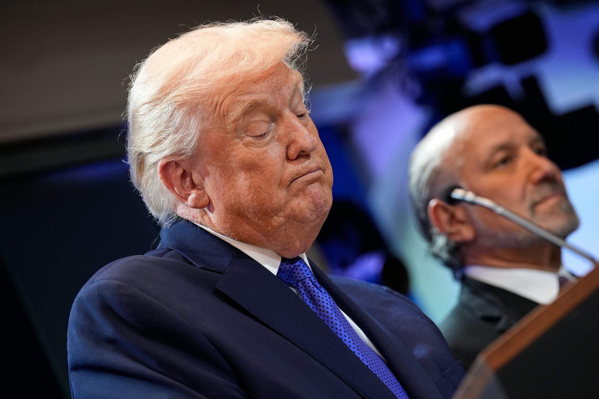 US President Donald Trump speaking into a microphone