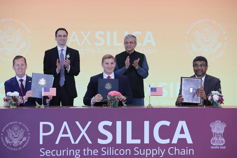 Various officials on a stage seen signing the Pax Silica Declaration between US and India